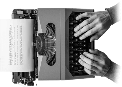 Hands typing on a vintage typewriter